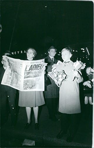 Foto vintage da velha mulher lendo jornal e um garoto segurando buquês.